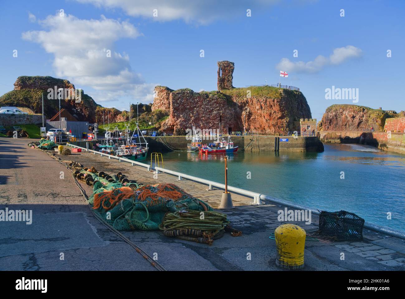 Vue vers l'ouest sur le port de Dunbar jusqu'aux ruines historiques du château.Belle journée claire.Bateaux de pêche colorés.East Lothian, Écosse, Royaume-Uni Banque D'Images