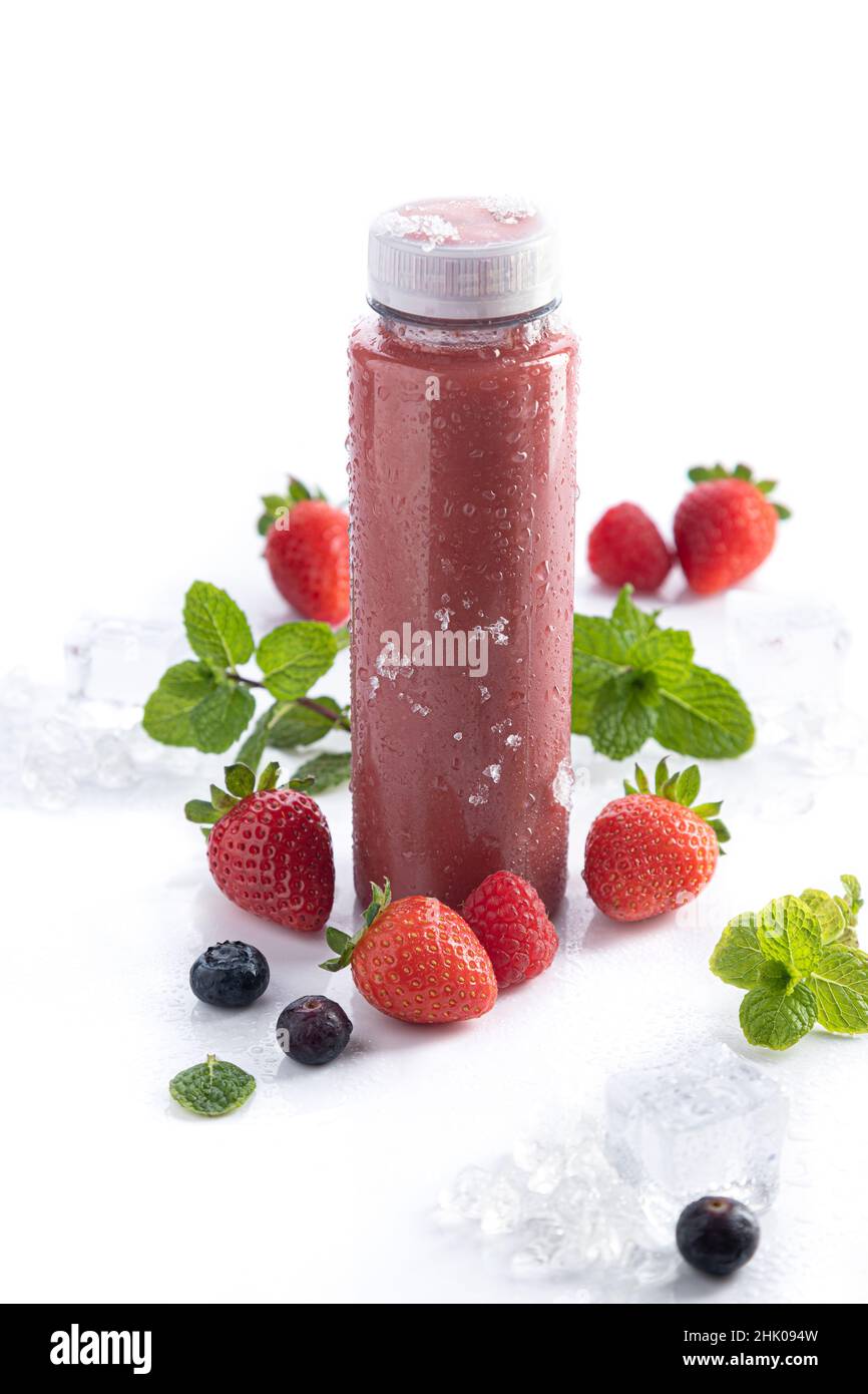 Bouteille de smoothie à la fraise avec superfood de détox sur fond blanc et espace de copie.Format vertical.Concept de boissons saines. Banque D'Images