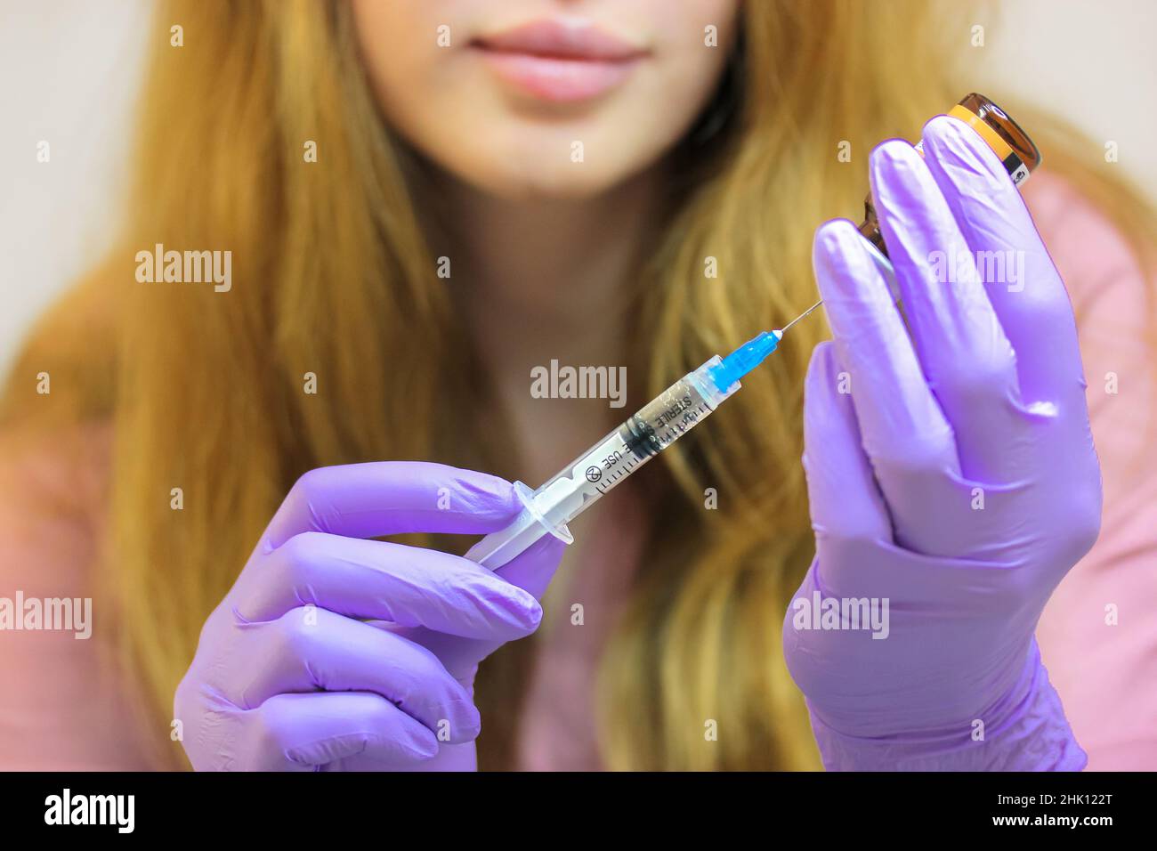 Seringue pour injection dans les mains de l'infirmière, femme médecin en gants de protection. Banque D'Images