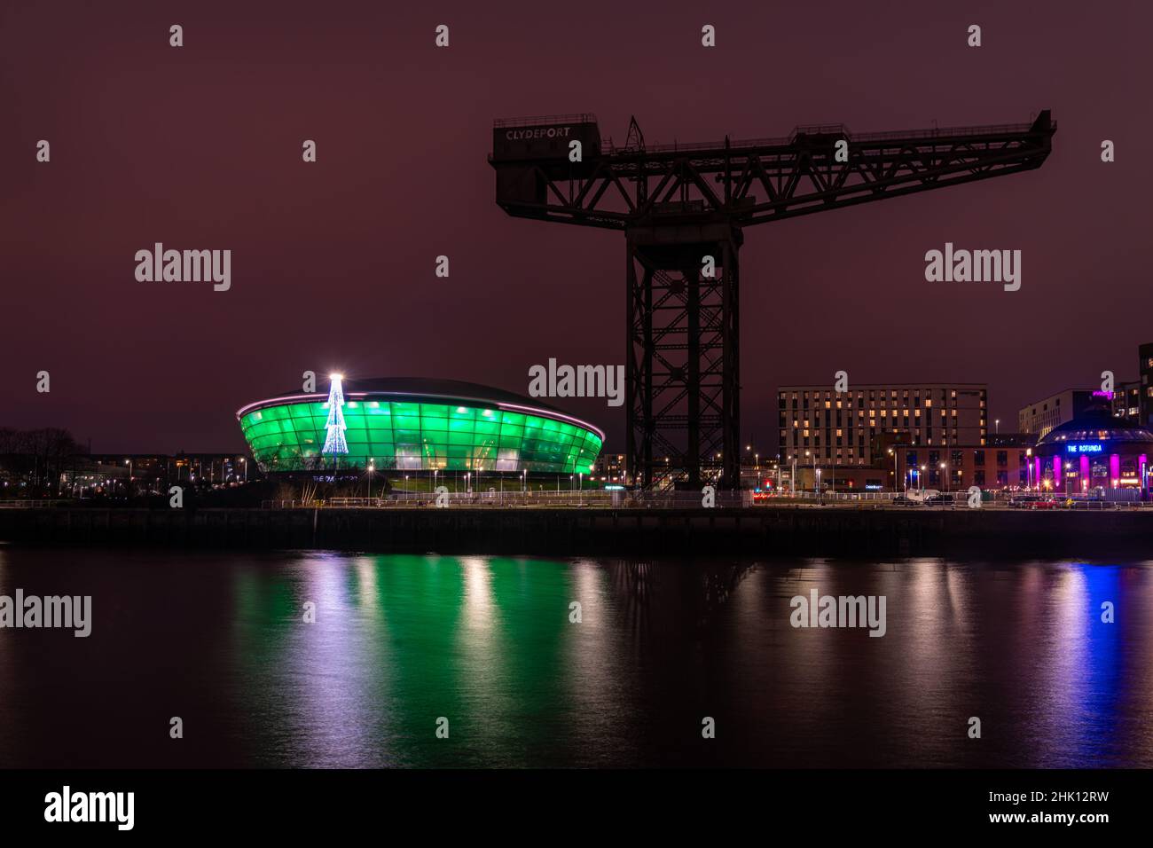 La grue Finnieston sur la rivière Clyde avec l'arène intérieure polyvalente Hydro illuminée en vert à l'arrière-plan. Banque D'Images