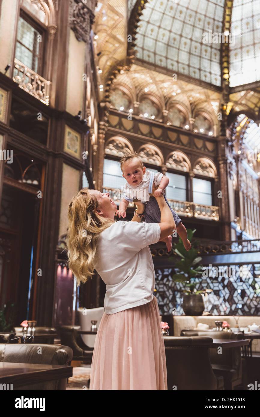 Belle femme en robe blanche avec son fils a un repos dans un café à Parisi Udvar hôtel dans le quartier V Budapest, Hongrie. Ouvert après restauration juin 20 Banque D'Images