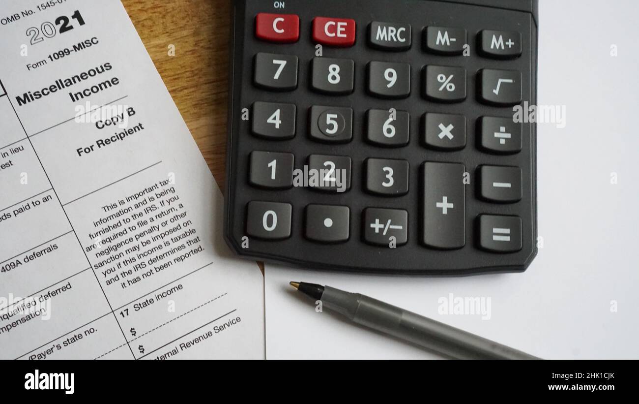 Utilisation d'une calculatrice pour produire des déclarations de revenus.LE formulaire US 1099 est affiché. Banque D'Images