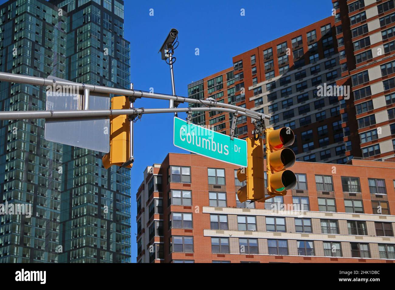 Panneau vert Big Columbus Drive suspendu sur un arc entre les feux de signalisation dans les rues du centre-ville de Jersey City Banque D'Images