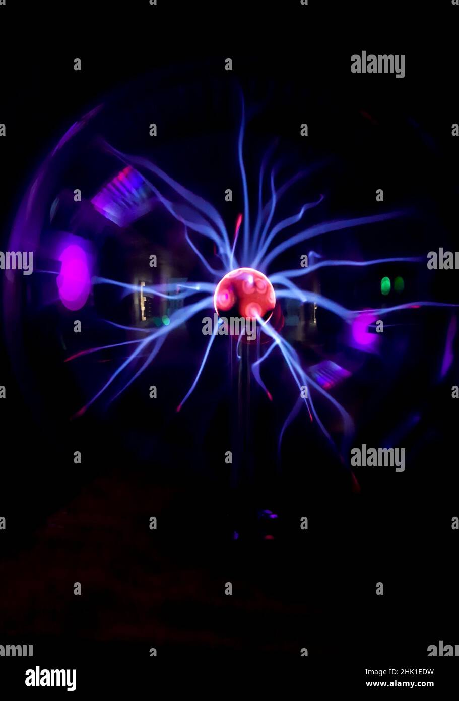 Boule de plasma avec des éclairs irisés dans différentes couleurs sur un fond très sombre Banque D'Images