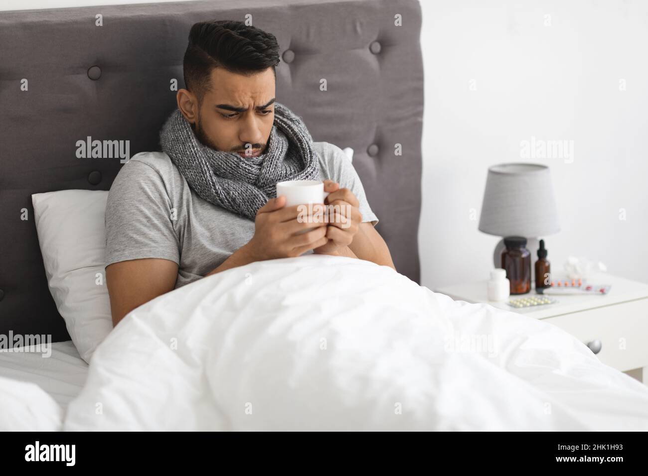Rhume et grippe.Portrait d'un homme arabe malade qui beuit le thé au lit  Photo Stock - Alamy