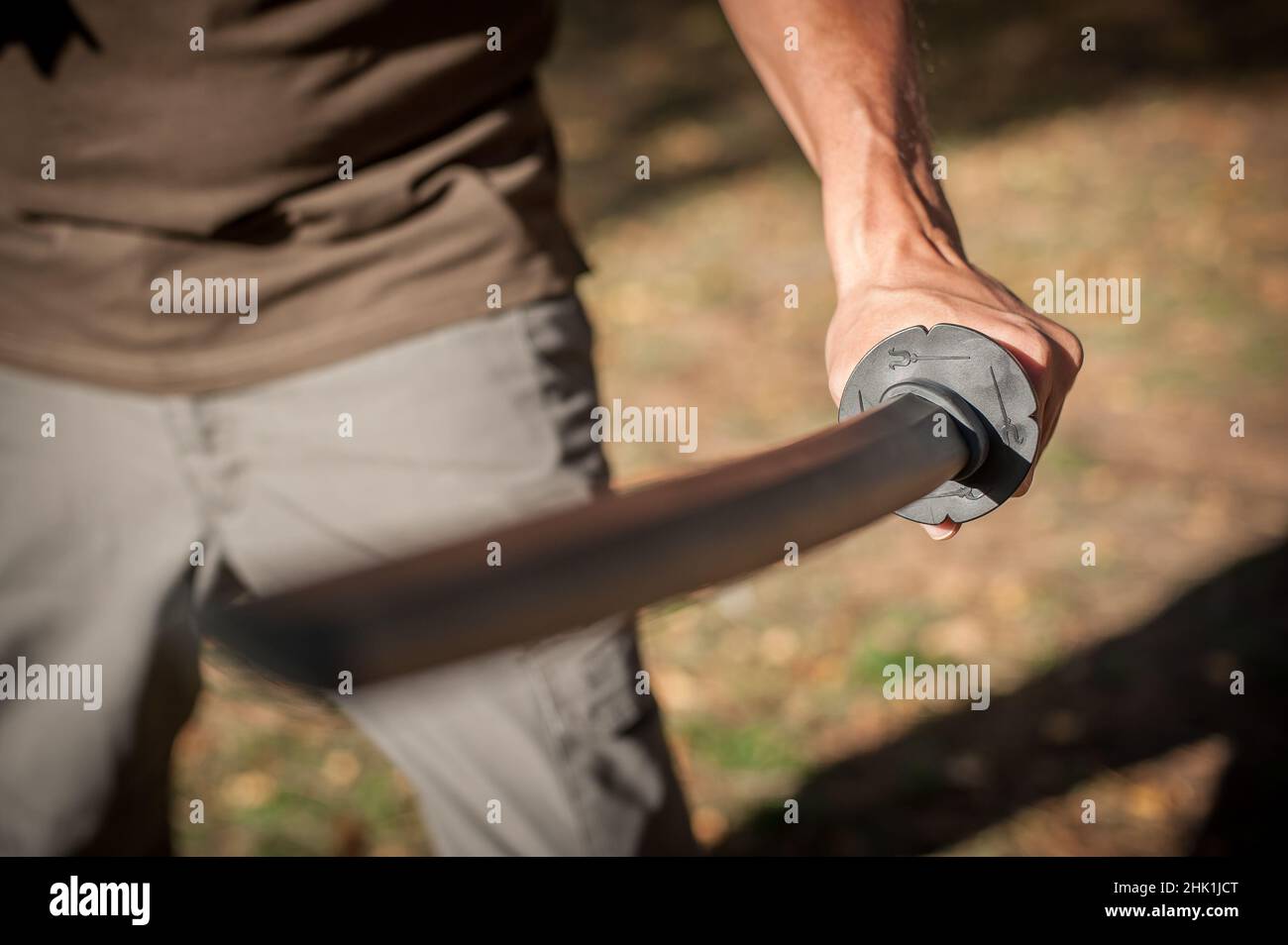 L'instructeur démontre les techniques de lutte contre l'épée de katana et les méthodes d'entraînement dans le parc public.Démonstration avec arme en plastique.Arme à long couteau tra Banque D'Images