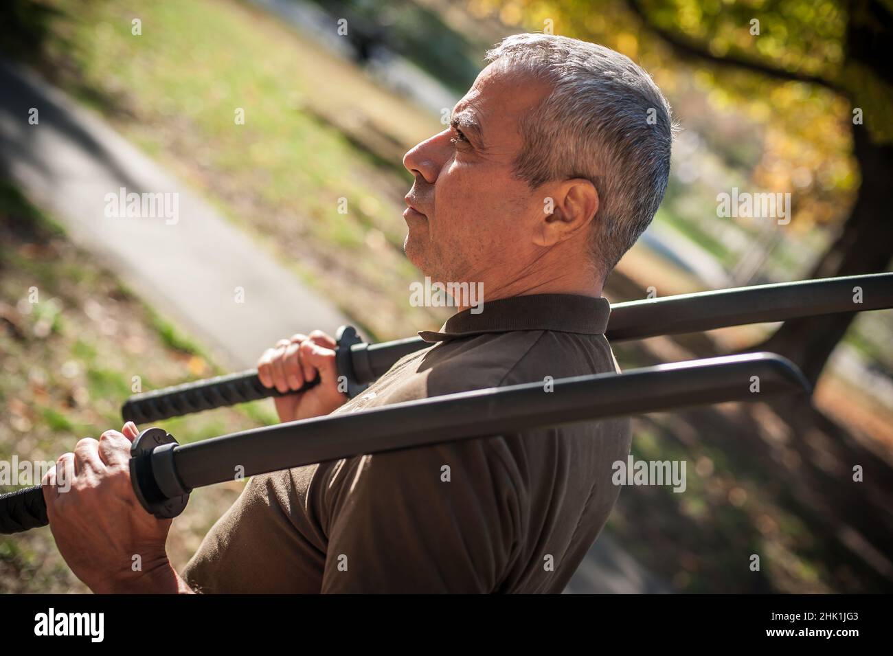 L'instructeur démontre les techniques de lutte contre l'épée de katana et les méthodes d'entraînement dans le parc public.Démonstration avec arme en plastique.Arme à long couteau tra Banque D'Images