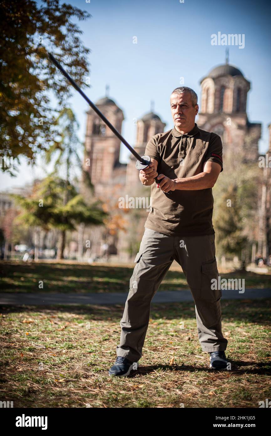 L'instructeur démontre les techniques de lutte contre l'épée de katana et les méthodes d'entraînement dans le parc public.Démonstration avec arme en plastique.Arme à long couteau tra Banque D'Images