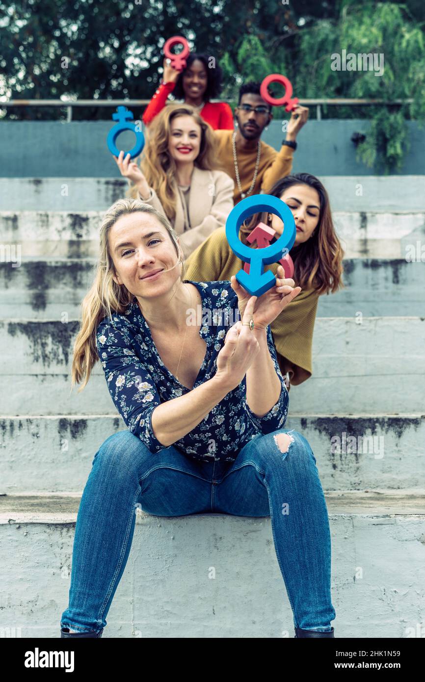 Une femme blonde pointe son doigt sur un symbole masculin Banque D'Images