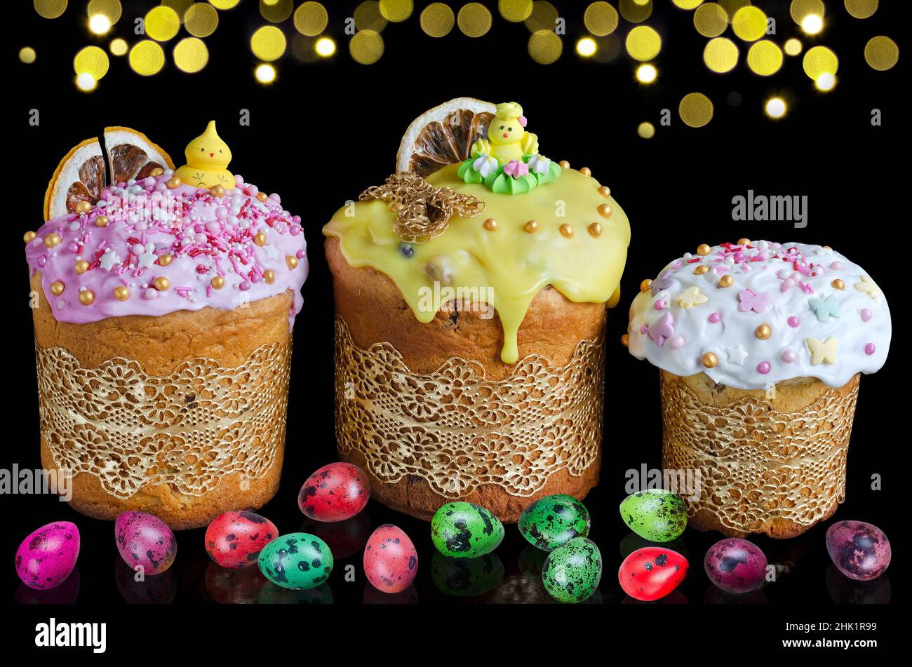 Gâteaux de Pâques décorés et œufs de caille colorés sur fond noir horizontal avec bokeh doré.Le concept de Pâques lumineuses Banque D'Images