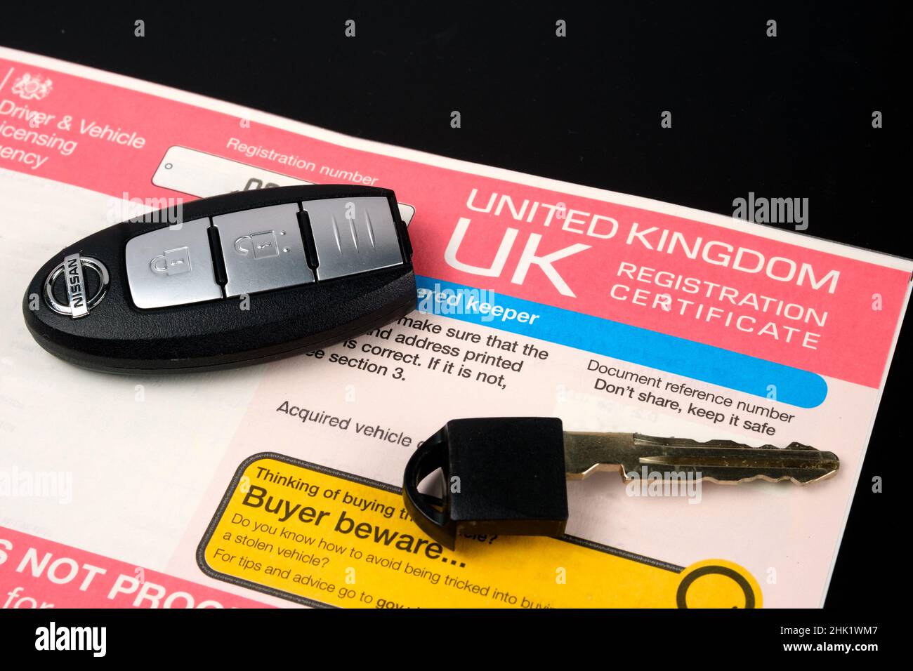 Certificat d'enregistrement d'origine britannique pour une voiture achetée et clé de voiture sur le dessus.Document d'immatriculation également appelé carnet de bord du véhicule V5C.Stafford Banque D'Images