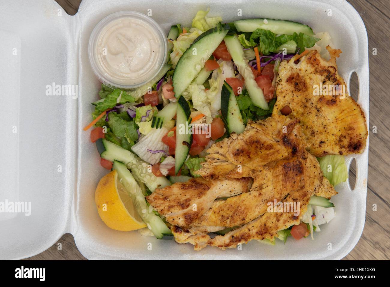 Vue en hauteur de l'ordre de départ de la salade de poulet grillée remplissant complètement la boîte de mousse de polystyrène. Banque D'Images