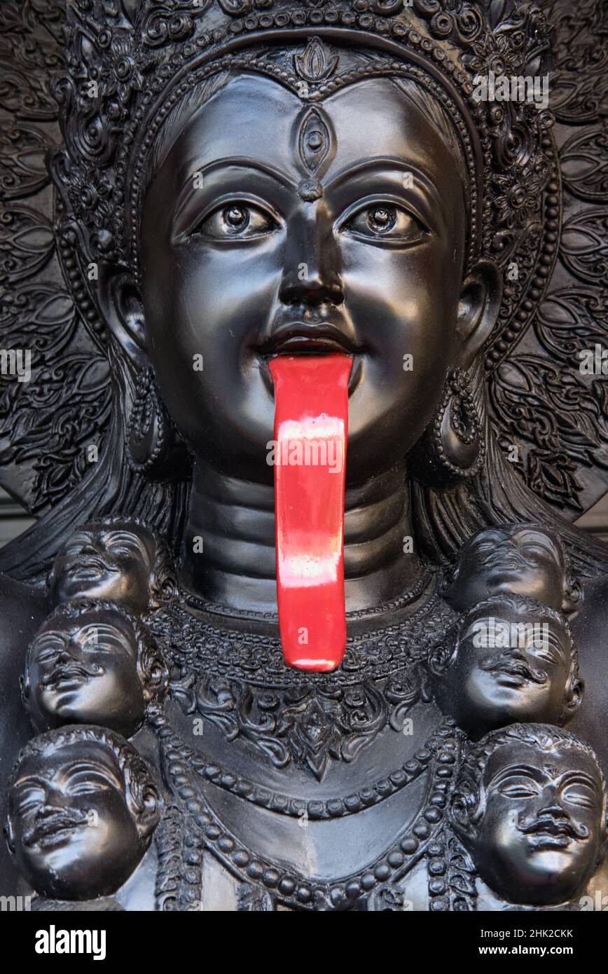 Statue noire de la déesse hindoue Kali avec une langue rouge qui goute le sang: À l'extérieur d'un magasin d'objets religieux à Bamrung Muang Road, Bangkok, Thaïlande Banque D'Images