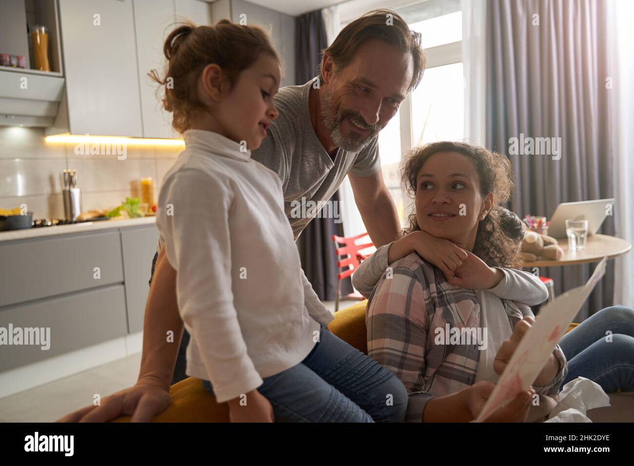 Fille et ses parents étudiant la peinture dans la cuisine Banque D'Images