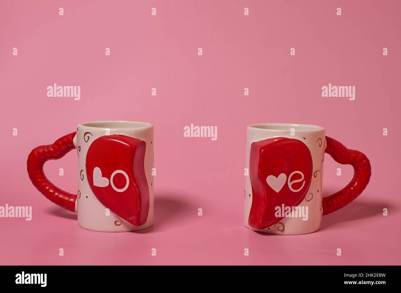 Deux mugs appariés avec l'inscription Amour et poignées sous forme de coeurs Banque D'Images