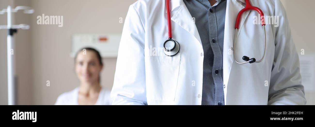 Le médecin tient la planchette à pince avec les documents médicaux en arrière-plan le patient est assis Banque D'Images