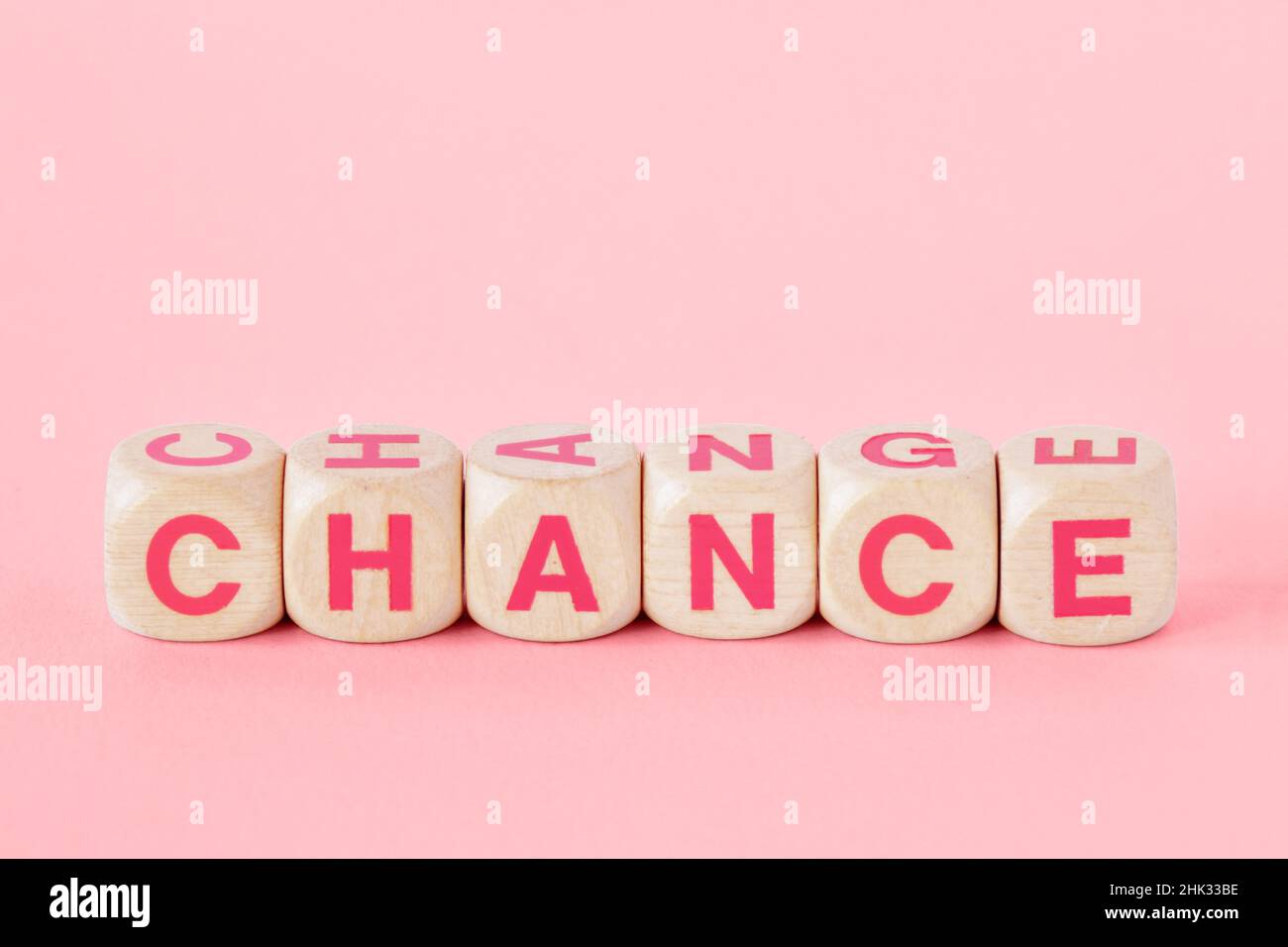 Mots chance et changement écrit avec des cubes de bois sur fond rose - concept de femme, chance et autonomisation Banque D'Images
