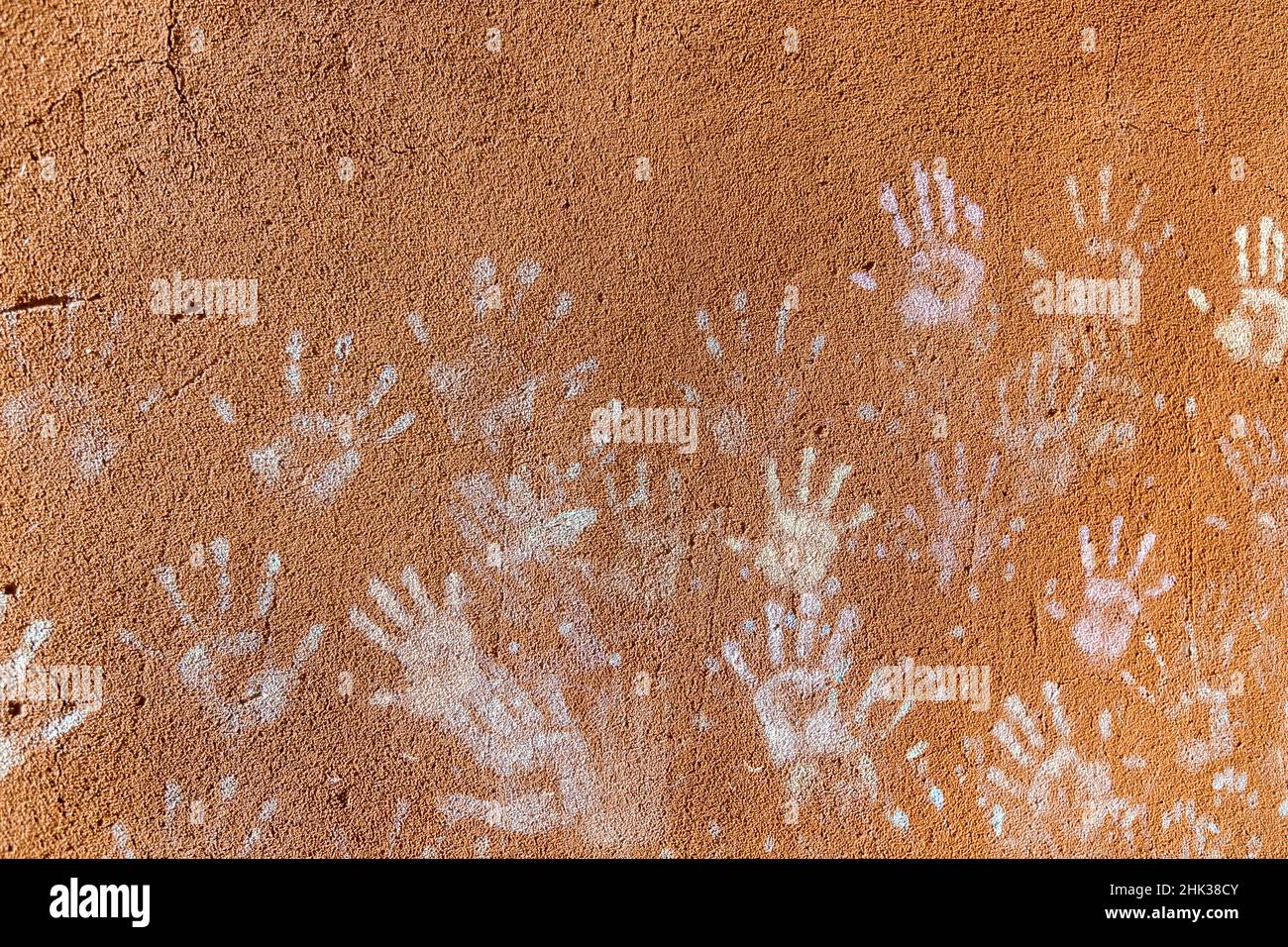 Les enfants jouent avec la craie, la couleur de la poussière des paumes, comme les empreintes sur le fond de façade de mur rugueux, le design d'enfance. Banque D'Images