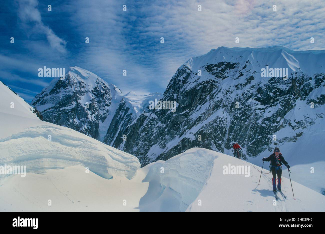 Femme et homme traversent le glacier Ruth sur des skis, parc national Denali, Alaska Banque D'Images