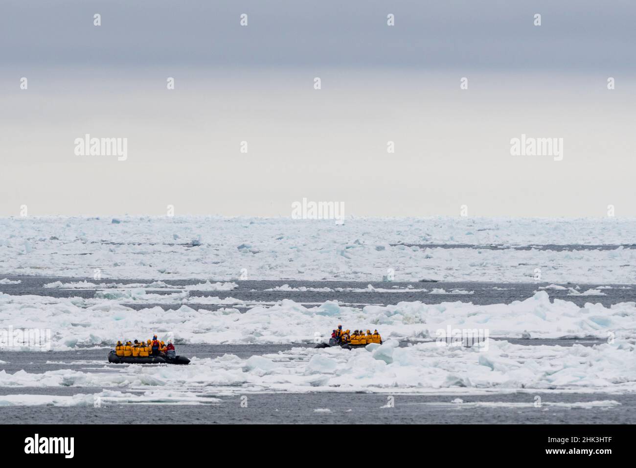 Touristes sur des bateaux gonflables explorant la calotte glaciaire polaire, au nord de Spitsbergen, en Norvège. Banque D'Images