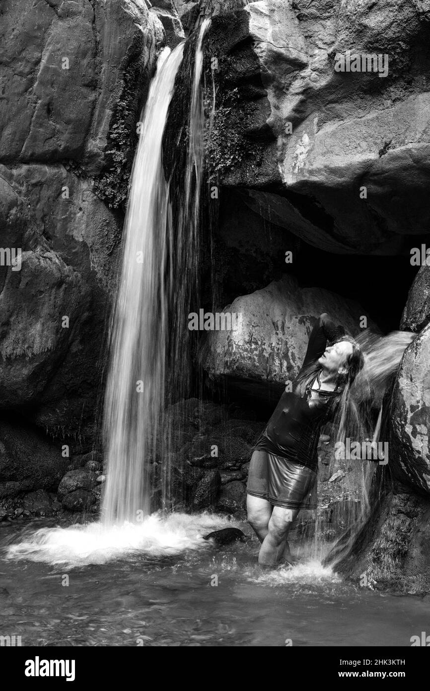 États-Unis, Arizona. Image noir et blanc. Le randonneur se rafraîchi dans la chute d'eau horizontale de Clear Creek, dans le parc national du Grand Canyon. Banque D'Images