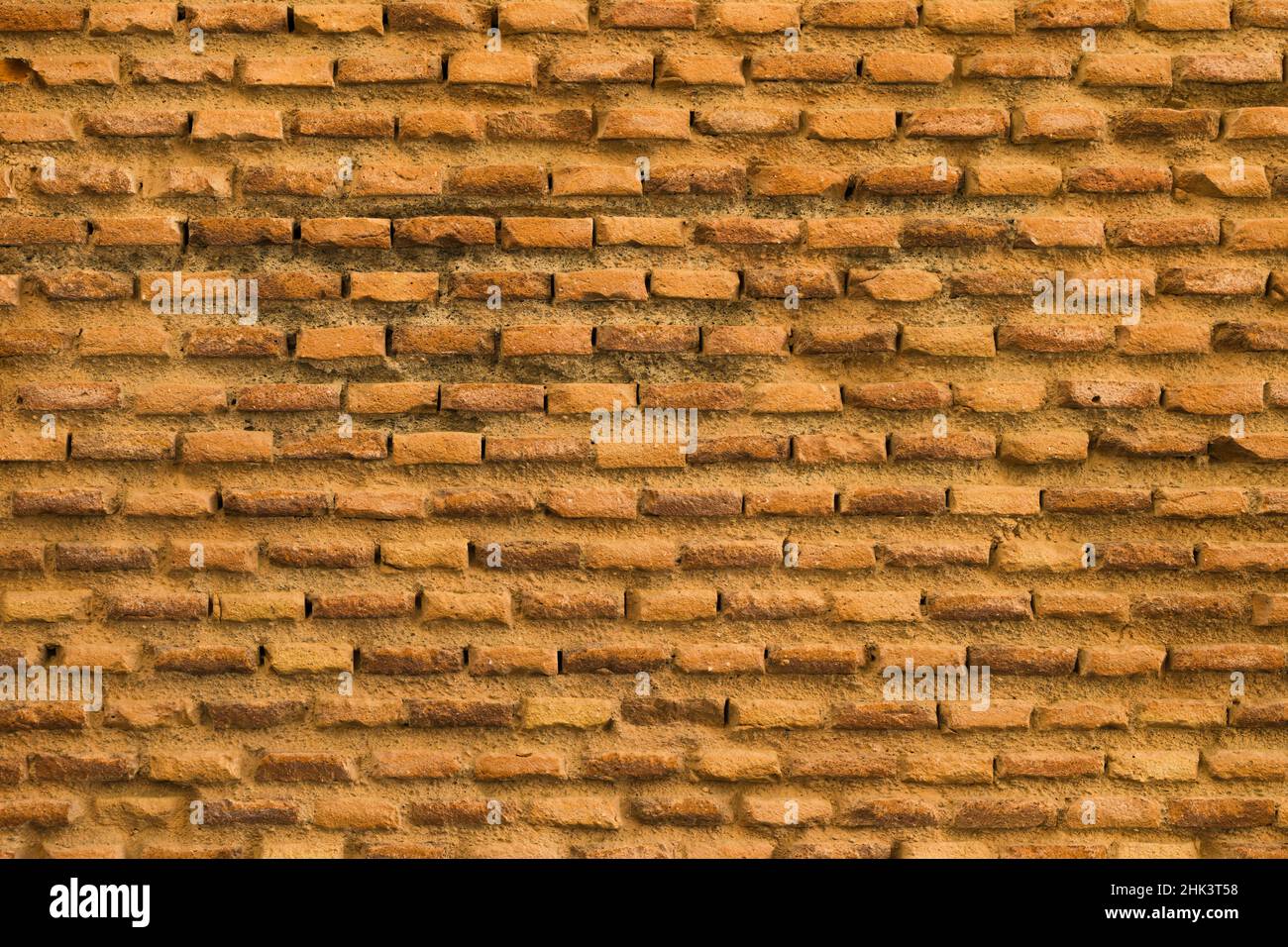 Mur de briques dans les tons orange d'un vieux mur médiéval.Concept avec arrière-plans très texturés. Banque D'Images