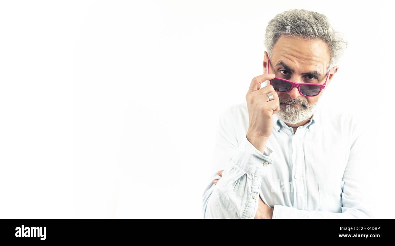 Homme aux cheveux gris en lunettes de soleil roses posant à l'appareil photo - concept de bonheur dans l'âge de personnes âgées - espace de copie isolé.Photo de haute qualité Banque D'Images
