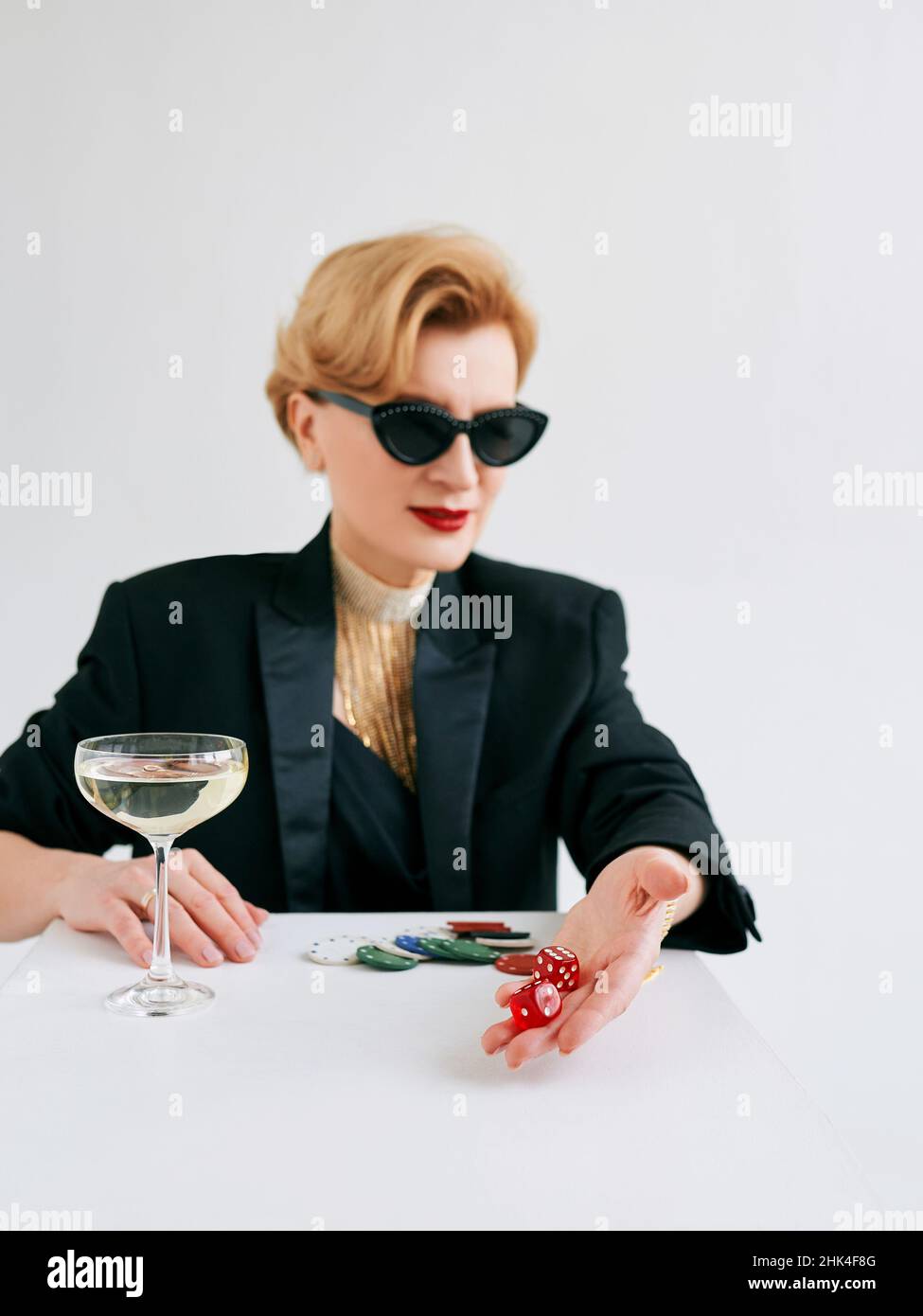 femme mature et élégante en smoking noir et lunettes de soleil au casino.Jeu, mode, visage de poker, concept de passe-temps. Banque D'Images