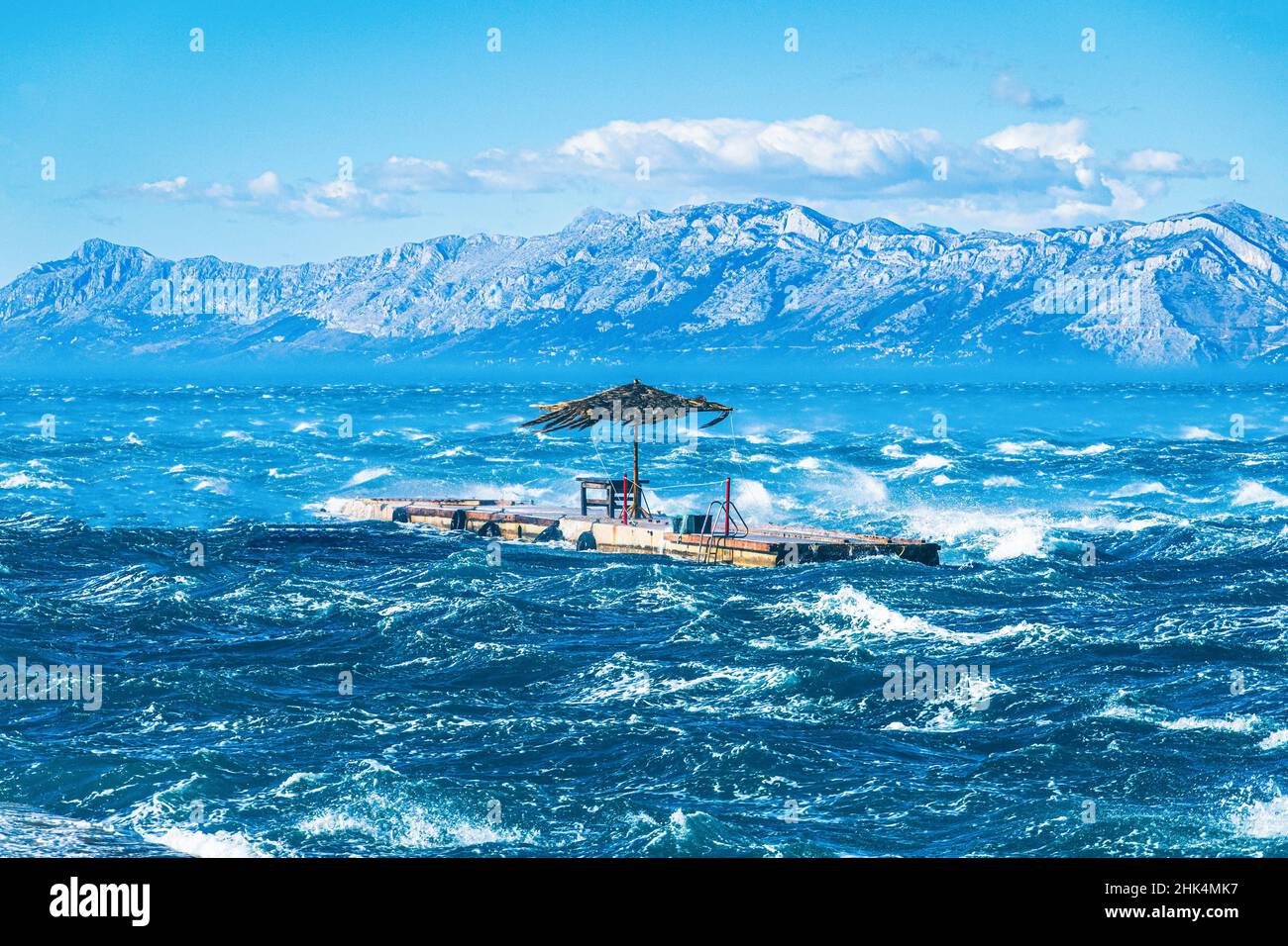 Quai flottant avec parapluie dans les vents forts sur la mer Banque D'Images