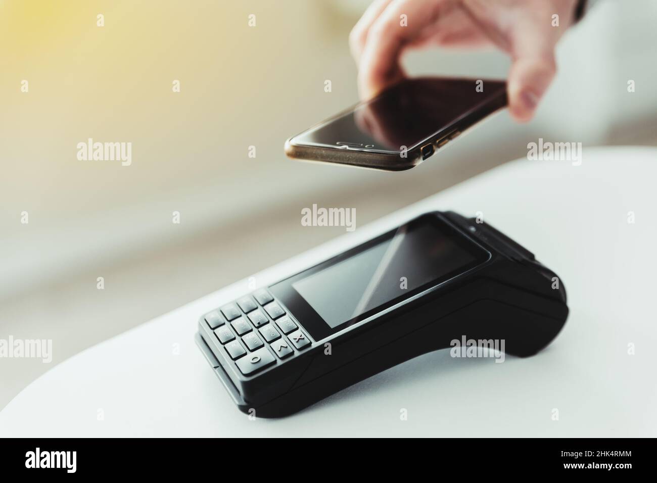 une personne anonyme utilise son smartphone pour payer un achat dans un magasin Banque D'Images
