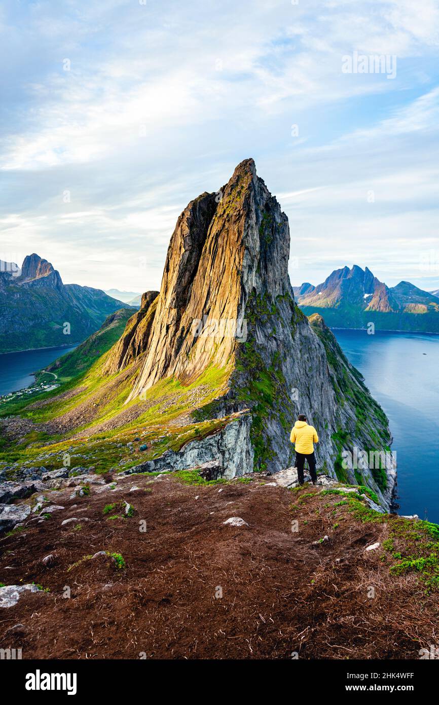 Personne debout devant la haute montagne de Segla et les fjords à l'aube, île de Senja, comté de Troms, Norvège, Scandinavie,Europe Banque D'Images