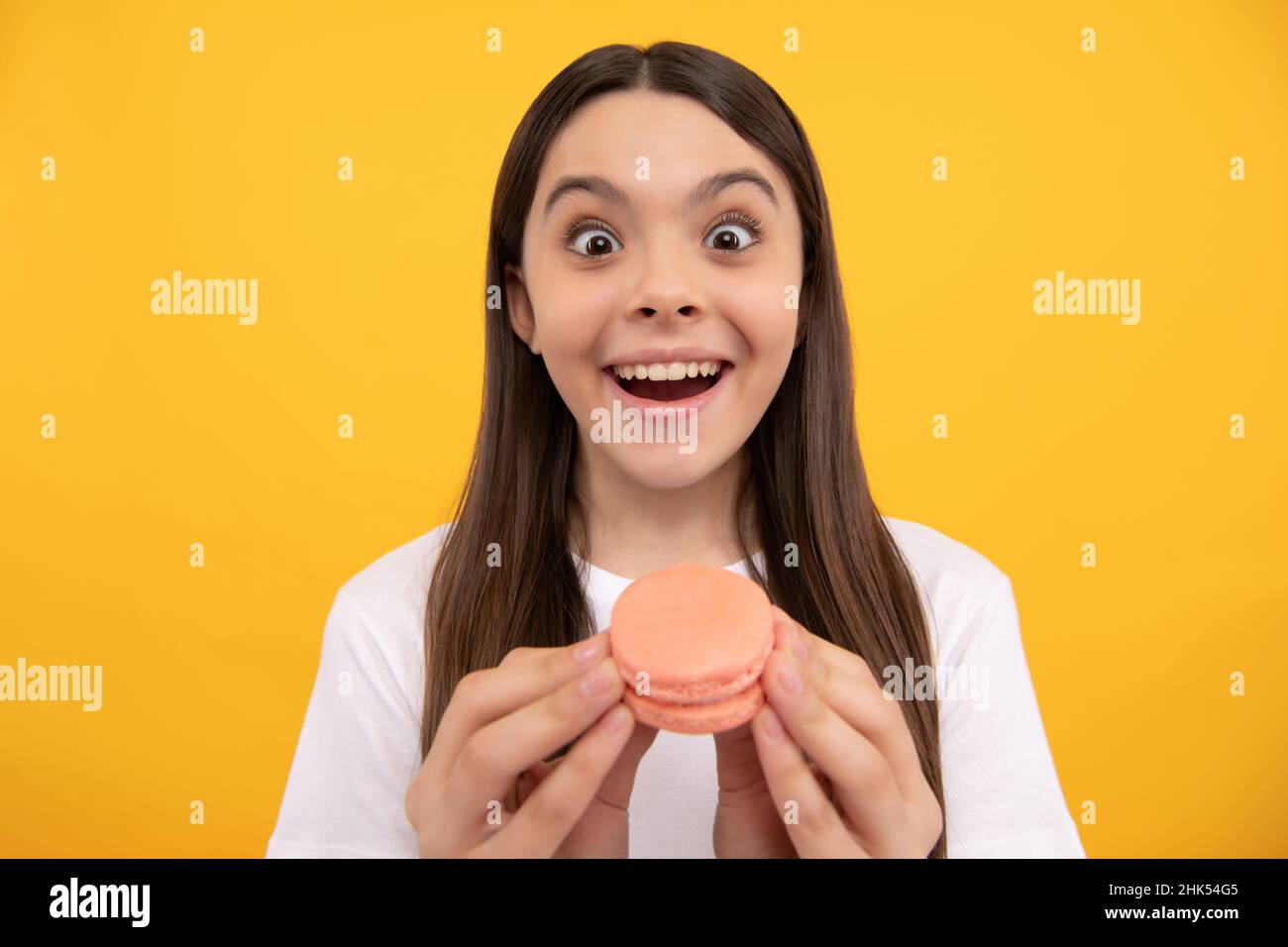 ouah. un enfant heureux avec une boulangerie dessert. un enfant tient le macaron français. un cookie macaron. Banque D'Images