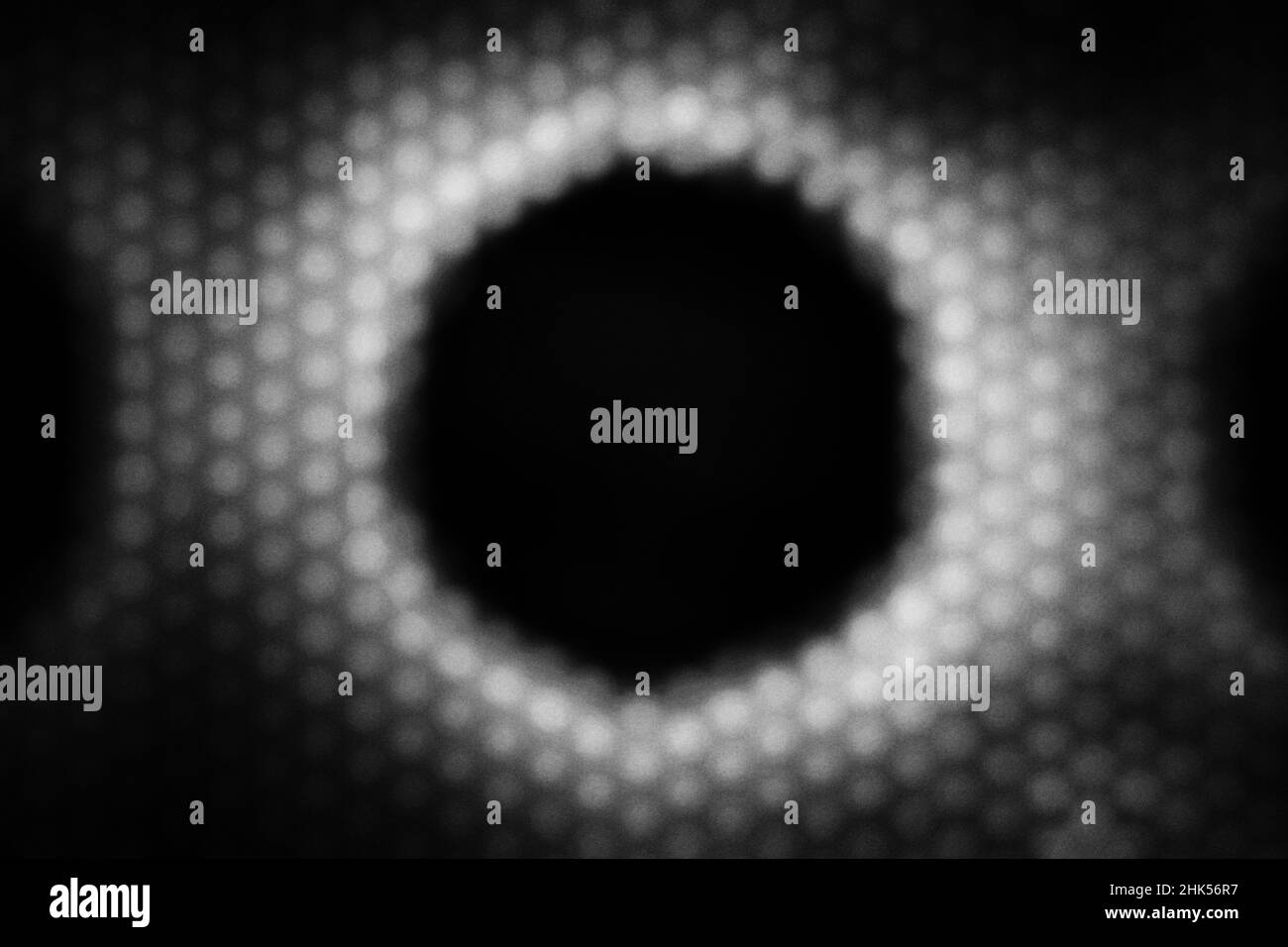 Bokeh simplifié d'un grand cercle entouré de petits points dans un motif abstrait répétitif. Banque D'Images