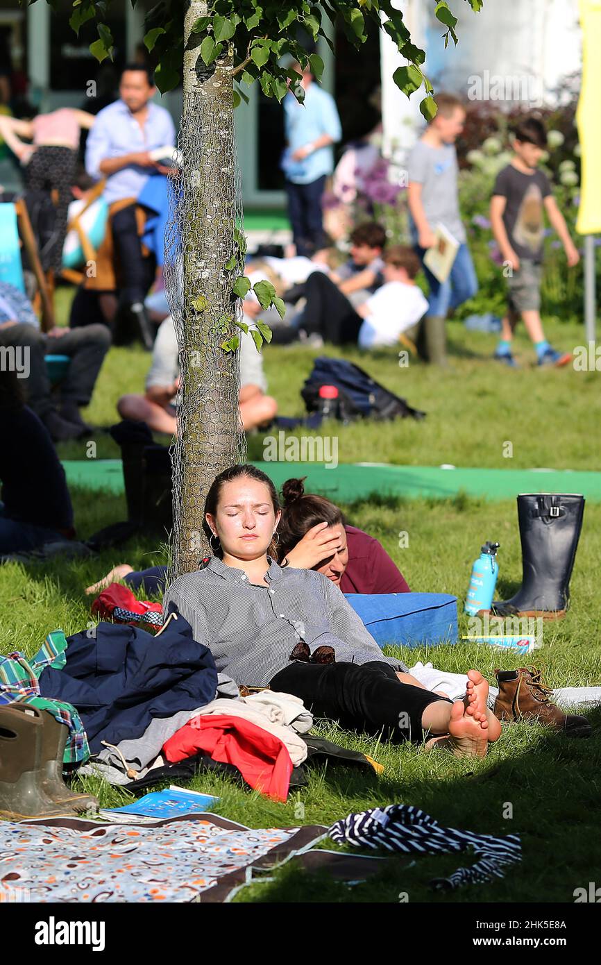 Hay Festival, une dame prend une pause dans le soleil chaud sur l'herbe sur le vert, à Hay-on-Wye, Powys, pays de Galles le 27th mai 2018. Banque D'Images
