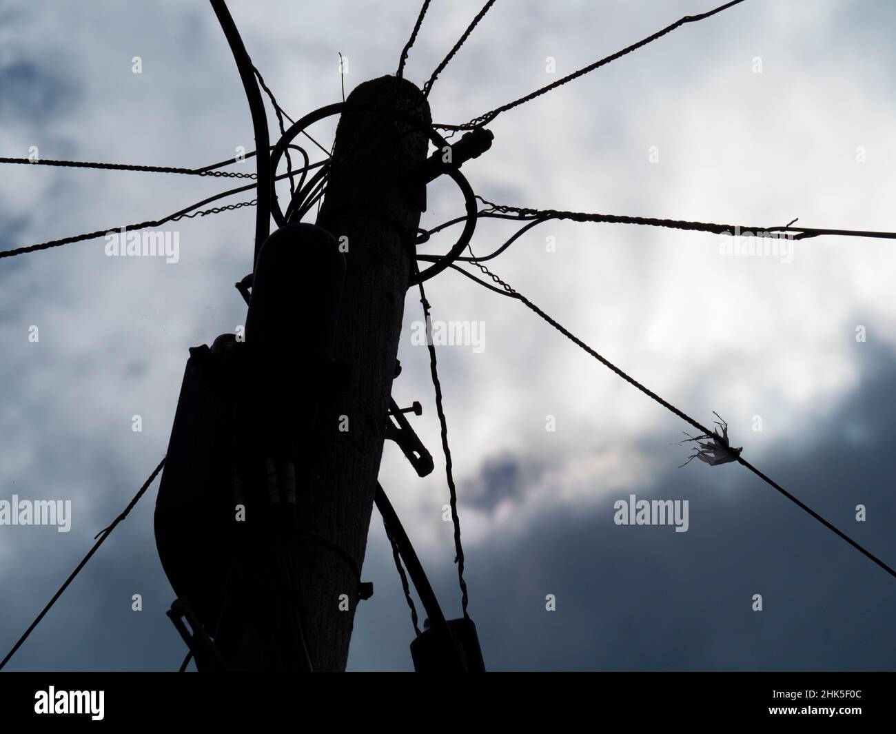 Ici, nous voyons un poteau transportant des câbles assortis lors de ma promenade quotidienne à travers Lower Radley jusqu'à la Tamise; tourné sous un ciel luciant. Banque D'Images