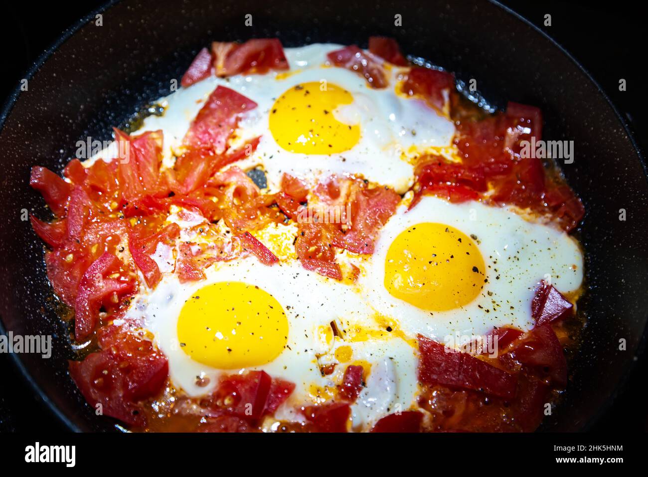 Œufs frits avec tomates sur une poêle.Gros plan, mise au point sélective. Banque D'Images