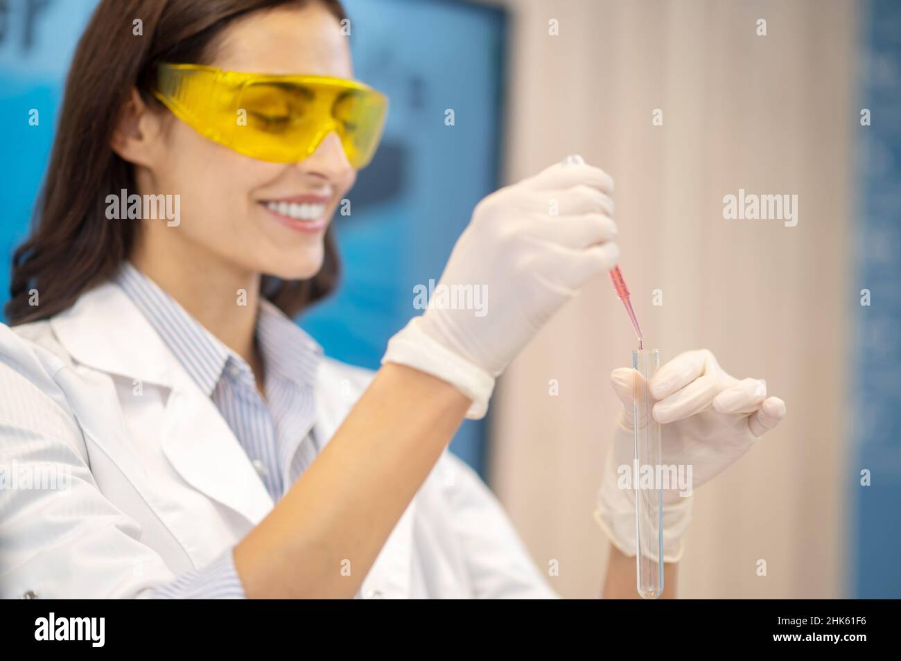 Femme faisant une expérience de chimie avec un tube à essai Banque D'Images