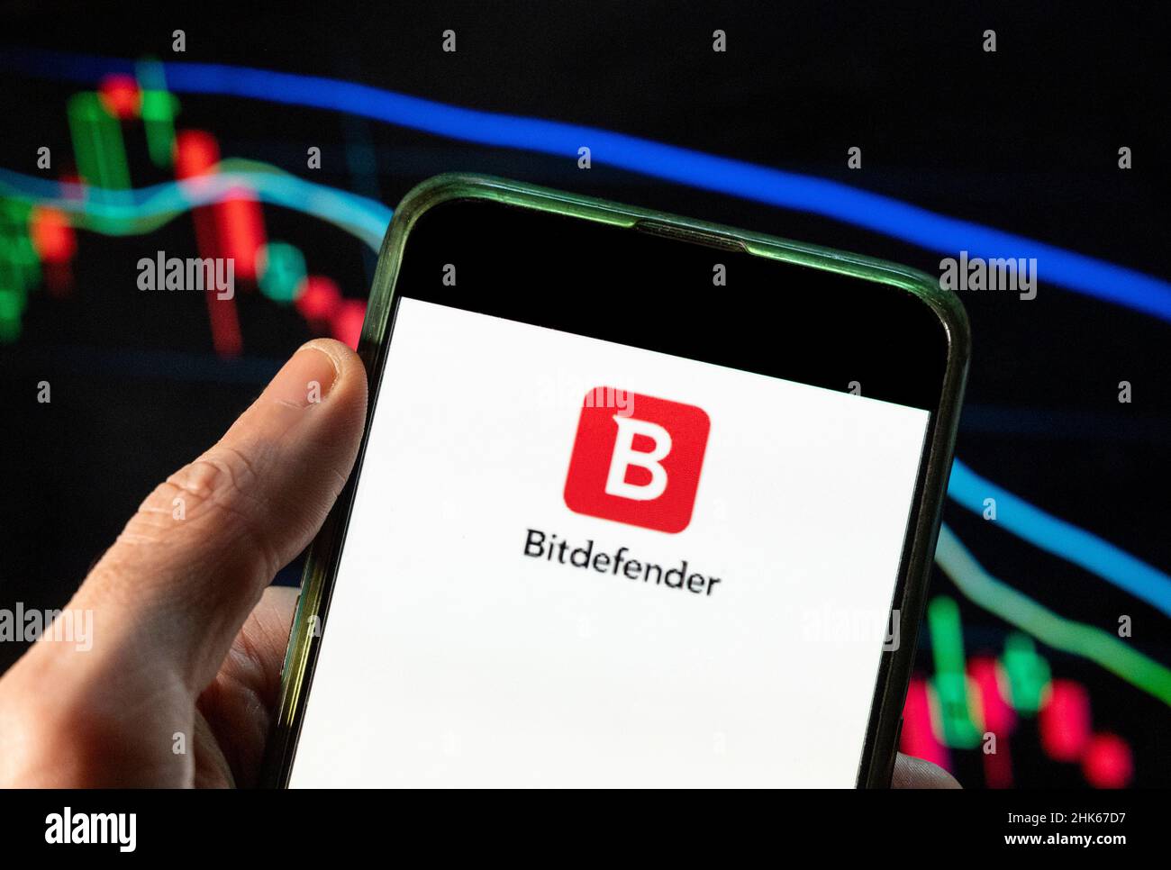 Dans cette photo, le logo de la société roumaine de cybersécurité et d'anti-virus Bitdefender est affiché sur un smartphone avec un graphique d'indice boursier économique en arrière-plan. Banque D'Images