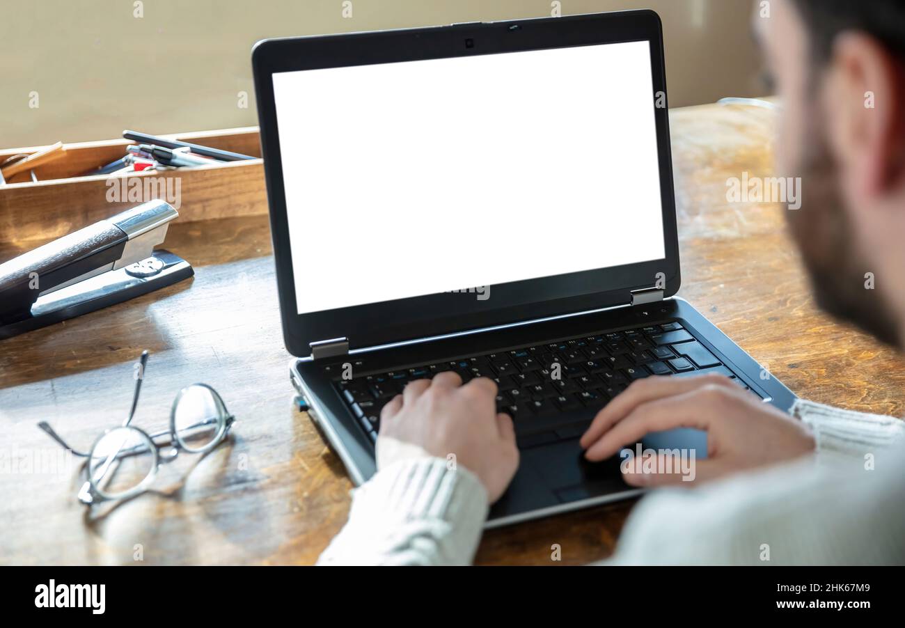 Ordinateur portable à écran vierge, bureau à domicile. Type homme, ordinateur portable ouvert sur le bureau, écran blanc vide, espace de copie Banque D'Images