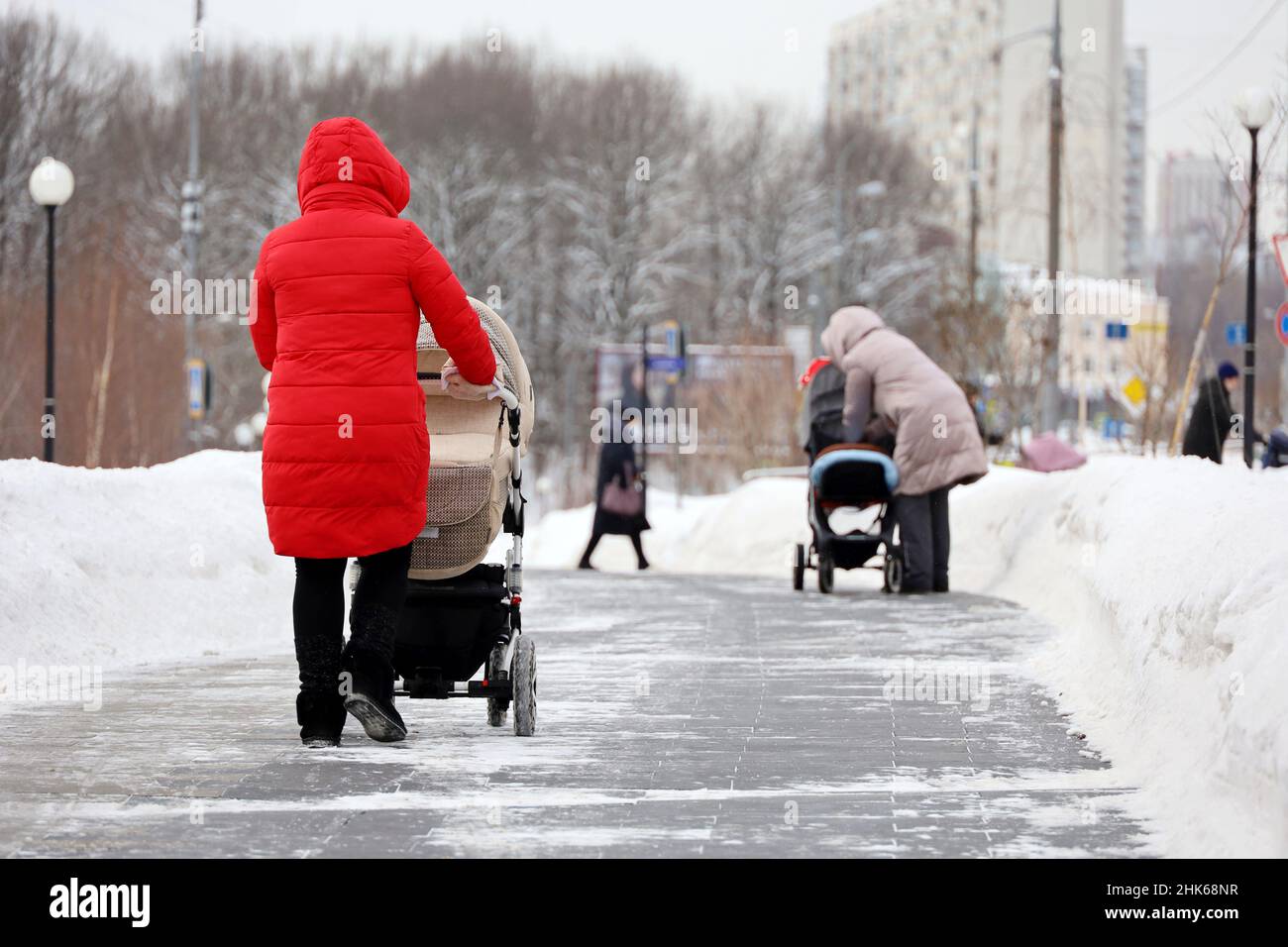 Les femmes marchant avec des landaus dans une rue.Les mères en ville d'hiver, les loisirs par temps de neige Banque D'Images