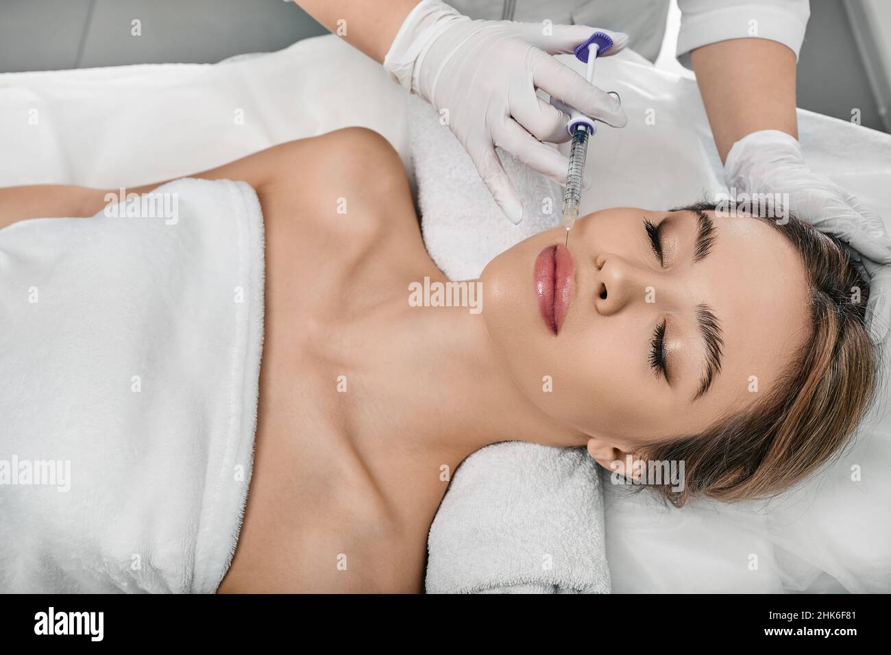Patiente pendant la procédure d'augmentation de la lèvre à la clinique de beauté avec un cosmétologue.Injection de remplissage pour de belles lèvres femelles augmentation avec hya Banque D'Images