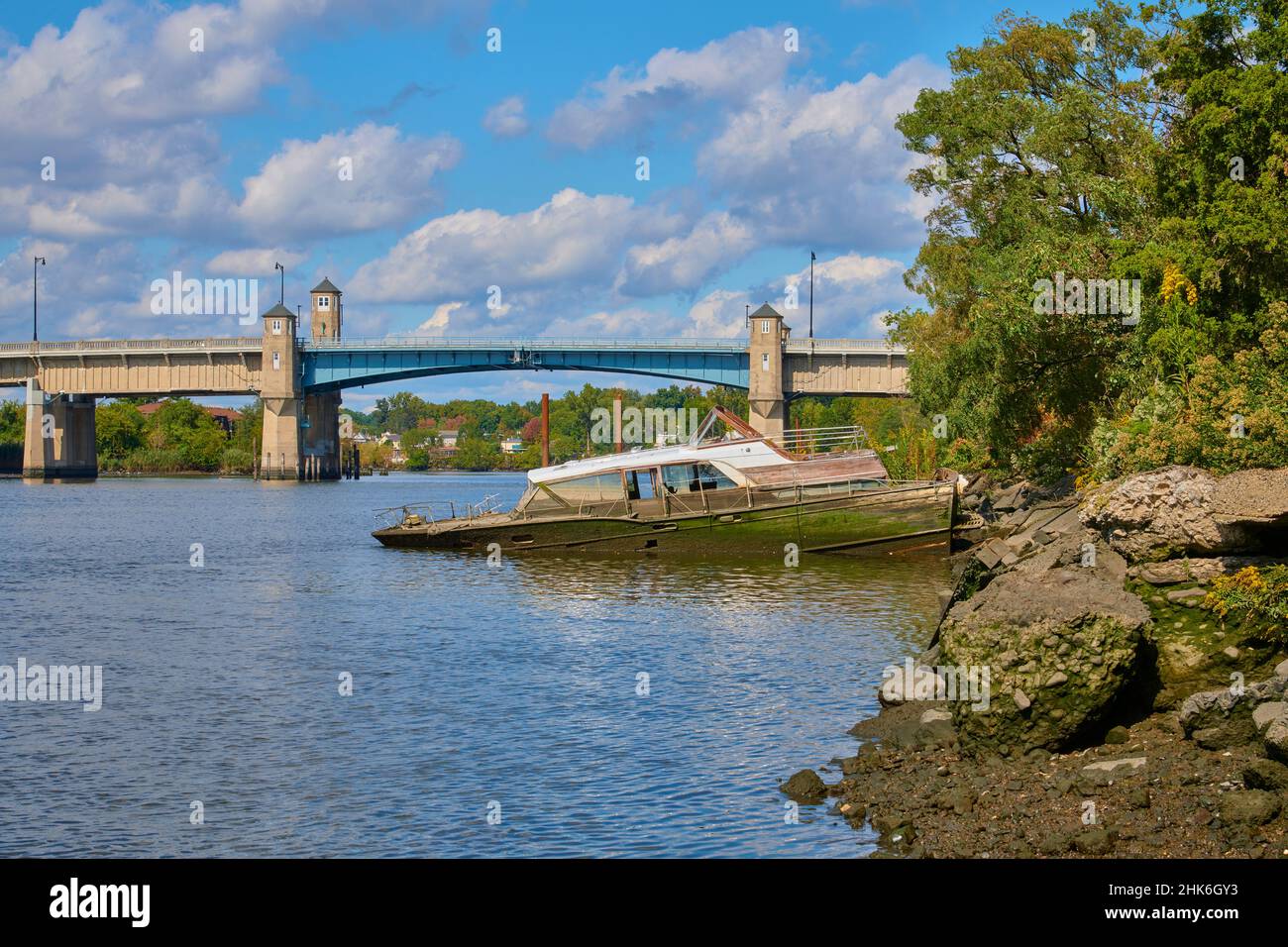 Bateau-cabine d'époque à moitié encastré.Sur les rives de la rivière Hackensack dans le New Jersey, États-Unis. En direction du nord vers le pont-levis sur Winant Avenue Banque D'Images