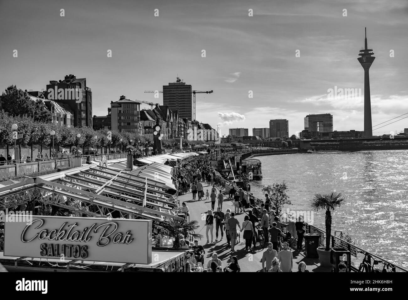 Des spectateurs d'un groupe de meneurs de gaieté s'assoient sur les marches de la tour du château, sur les rives du Rhin, à Düsseldorf, en Allemagne Banque D'Images