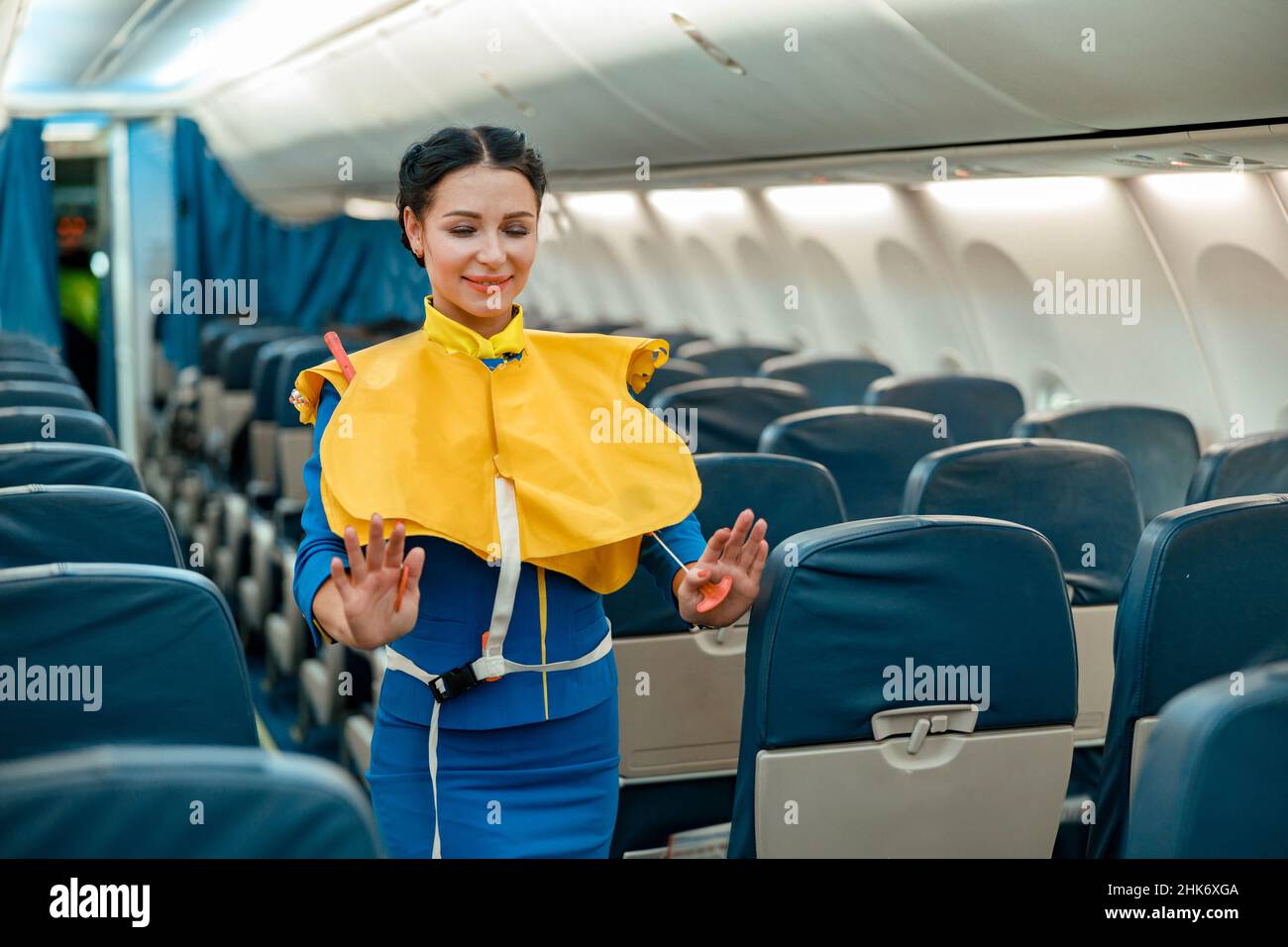 Un employé de bord démontre comment utiliser la gilet de sauvetage dans un avion Banque D'Images