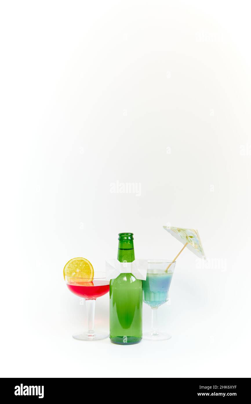 Ensemble de bouteille de bière en verre vert vide avec deux gobelets en verre transparent sur fond blanc.CopySpace.Photographie verticale. Banque D'Images