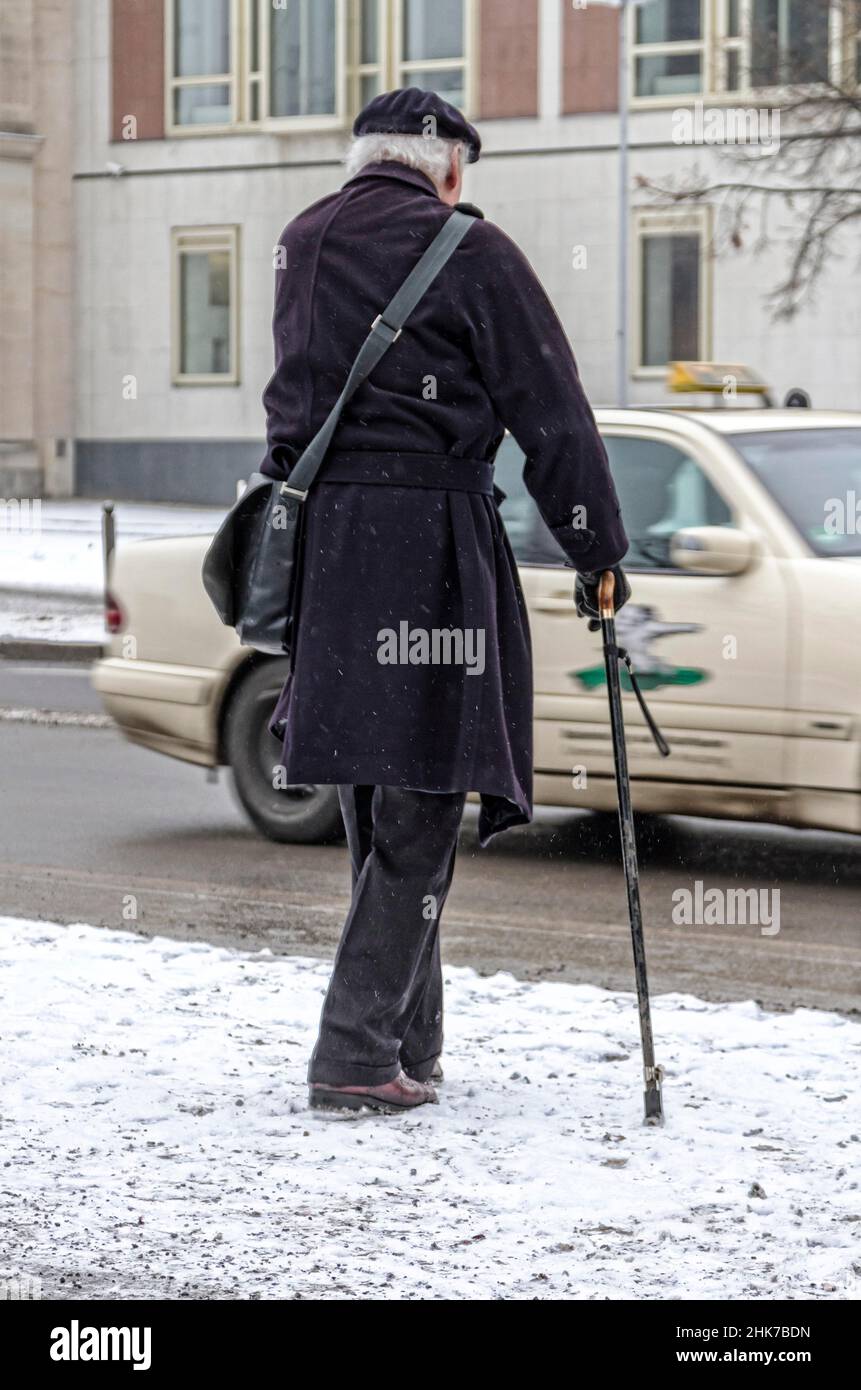 Senior avec bâton de marche dans les conditions de route hivernales, Berlin, Allemagne Banque D'Images