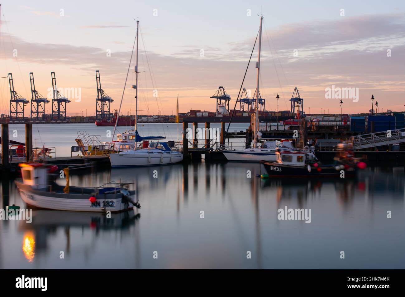 Le soleil commence à se coucher, en regardant vers le port de Felixstowe et des grues du port de Harwich et de la jetée de Ha'penny.Harwich & Dovercourt, Essex, Royaume-Uni Banque D'Images