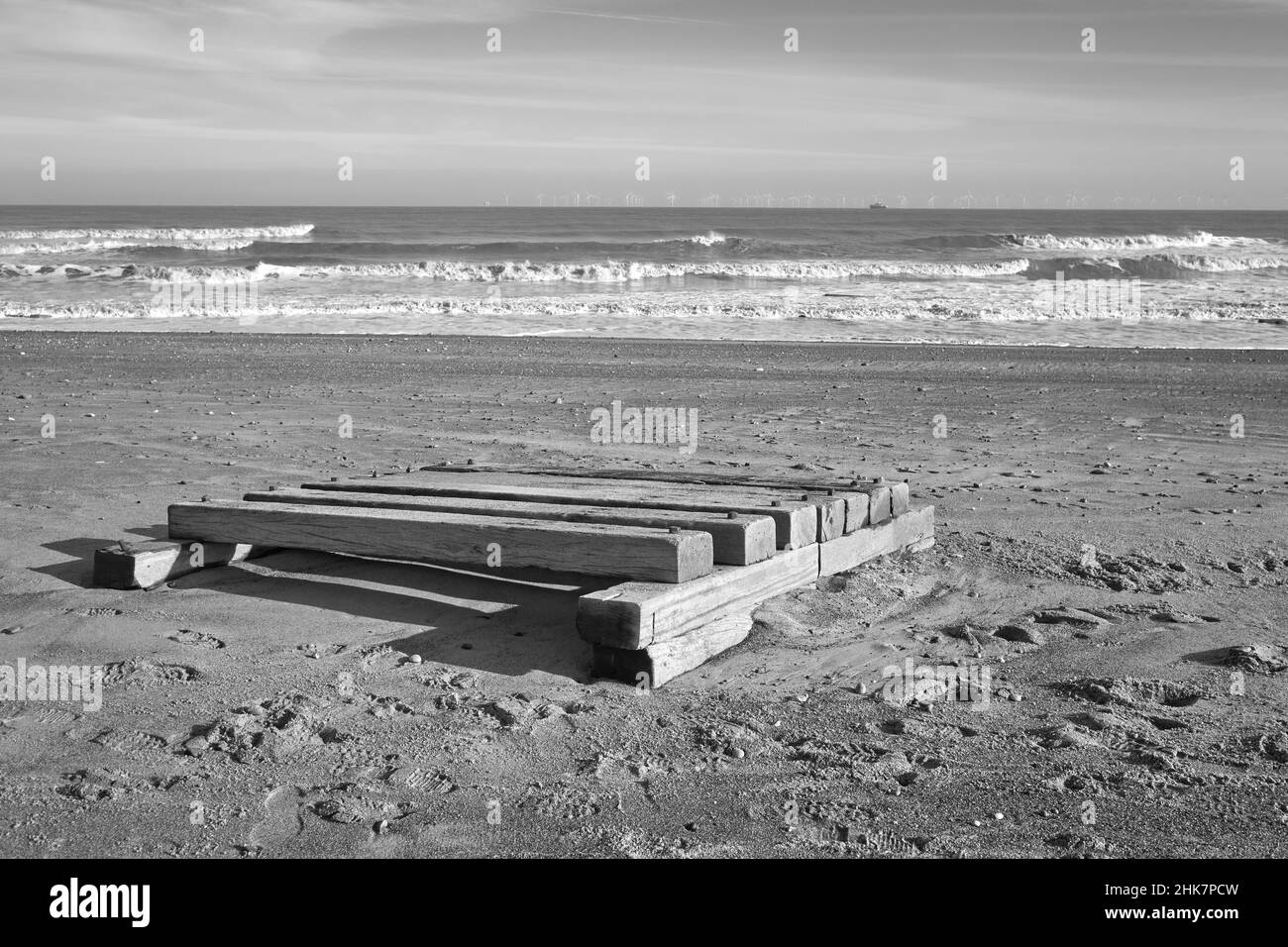 Il y a un gros radeau en bois qui s'est lavé sur une plage Banque D'Images