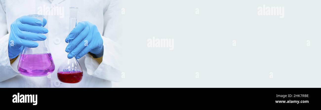 Banderole avec chimiste contenant un erlenmeyer ou un flacon conique en verre pour titration avec des liquides brillants avec espace de copie.Laboratoire de chimie analytique moderne Banque D'Images