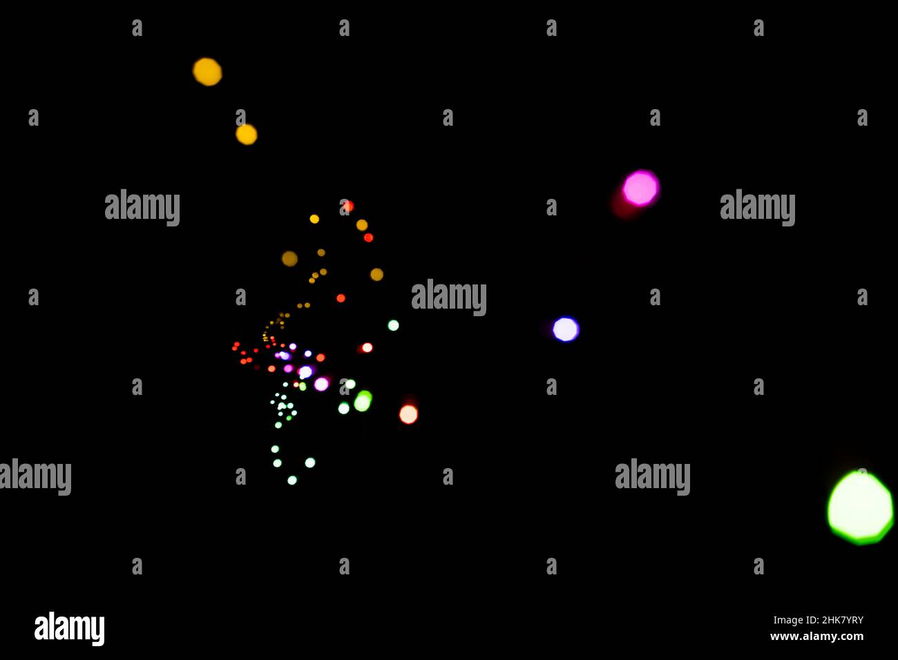 Bokeh de lumières de différentes couleurs dans l'obscurité Banque D'Images